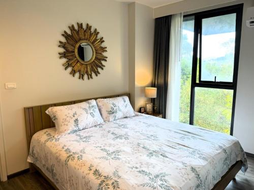 a bedroom with a bed and a mirror on the wall at Deck Condo private apartment by Lofty in Patong Beach
