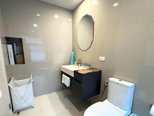 a bathroom with a toilet and a sink and a mirror at Deck Condo private apartment by Lofty in Patong Beach