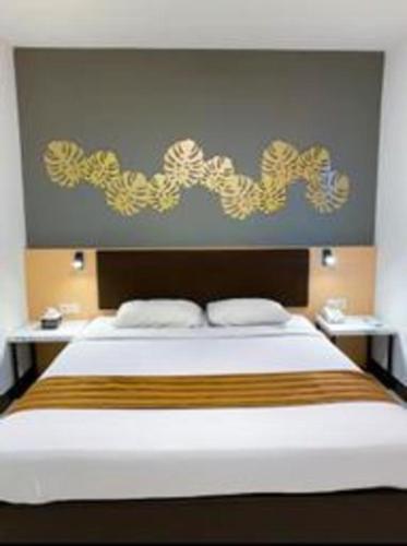 a bedroom with a large bed with a large headboard at Tematik Hotel Pluit in Jakarta