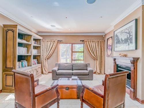 un soggiorno con un divano, un tavolo e delle sedie di Villa Vuso by Euphoric Leisure a Benoni