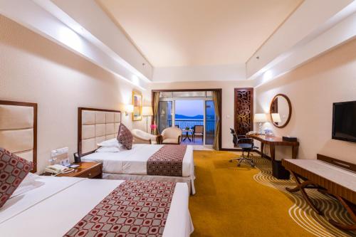 a hotel room with two beds and a balcony at Country Garden Phoenix Hotel Chizhou Jiuhua Mountain in Chizhou
