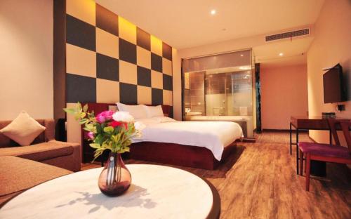 a hotel room with a bed and a vase of flowers at Hangzhou Berman Hotel in Hangzhou