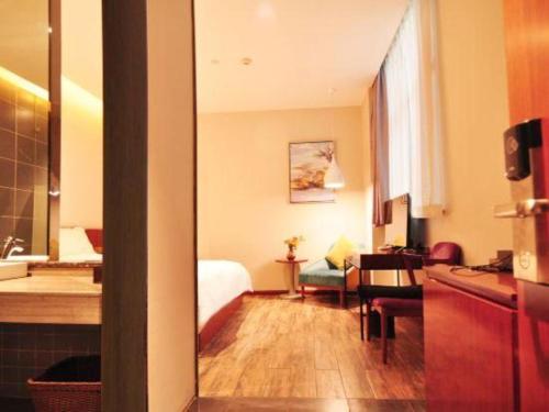 a hotel room with a bed and a bathroom at Hangzhou Berman Hotel in Hangzhou