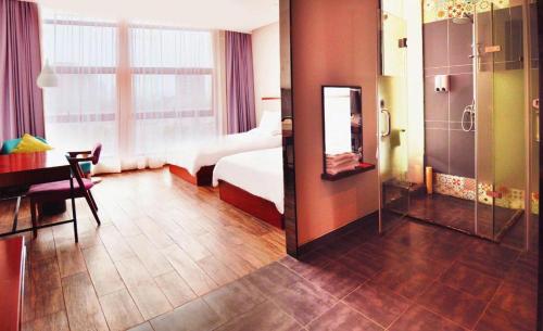a hotel room with a bed and a mirror at Hangzhou Berman Hotel in Hangzhou