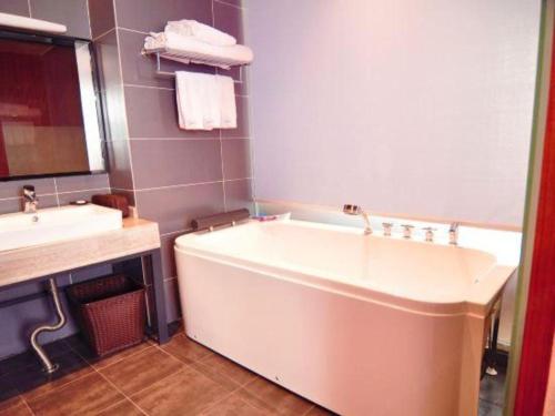 a bathroom with a large tub and a sink at Hangzhou Berman Hotel in Hangzhou