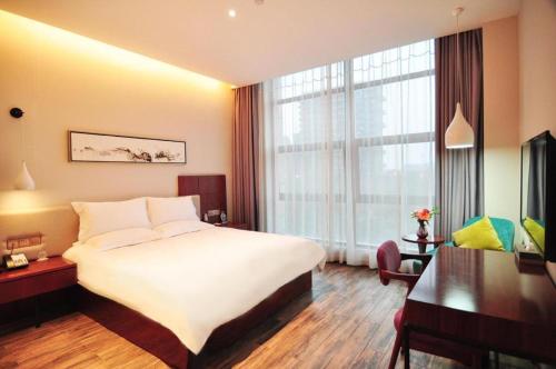 a hotel room with a bed and a large window at Hangzhou Berman Hotel in Hangzhou