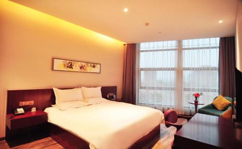 a hotel room with a large bed and a window at Hangzhou Berman Hotel in Hangzhou