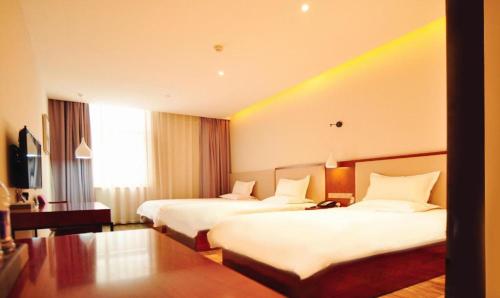 a hotel room with two beds and a table at Hangzhou Berman Hotel in Hangzhou