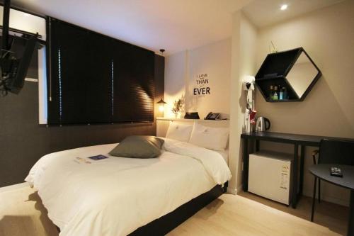 a bedroom with a bed and a table and a window at Hotel Yam ANDONG in Andong