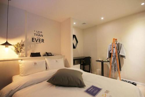 a bedroom with a bed and a sign that says less than ever at Hotel Yam ANDONG in Andong