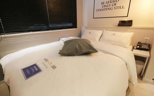 a white bed with a pillow on top of it at Hotel Yam ANDONG in Andong