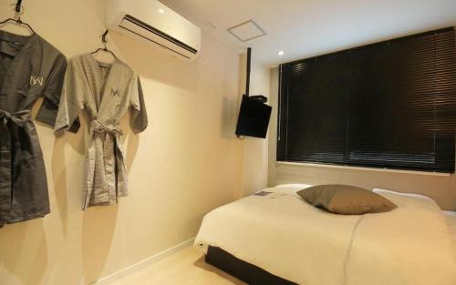 a bedroom with a bed and clothes hanging on a wall at Hotel Yam ANDONG in Andong