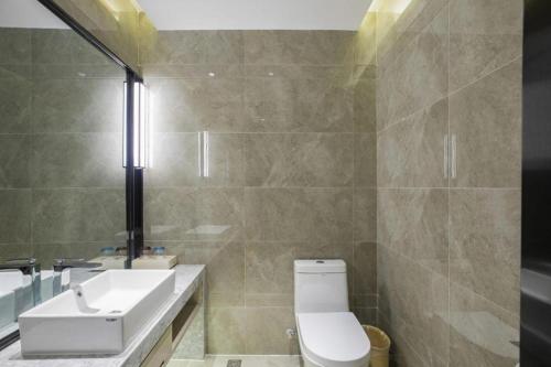 a bathroom with a white toilet and a sink at Echarm Hotel Guilin North High Speed Railway Station in Guilin