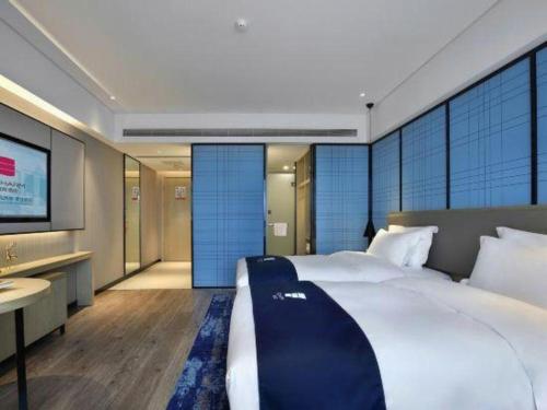 a bedroom with a large bed and a television at Echarm Hotel Guilin North High Speed Railway Station in Guilin