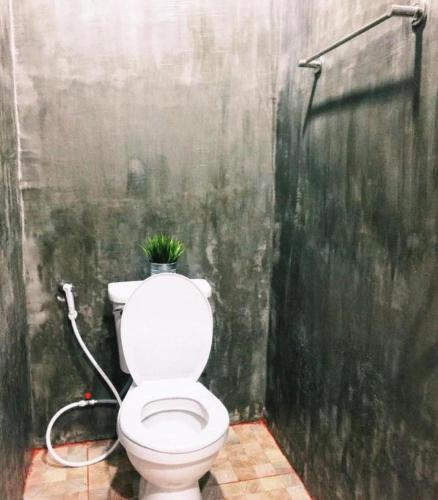 a bathroom with a toilet with a plant on it at Rim Kaeng resort in Phetchaburi