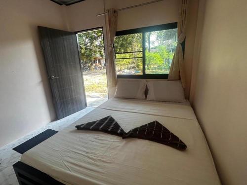 a bed in a room with two pillows on it at Chomjan Hostel in Ko Phayam