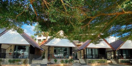 a building with a large tree in front of it at Rim Kaeng resort in Phetchaburi