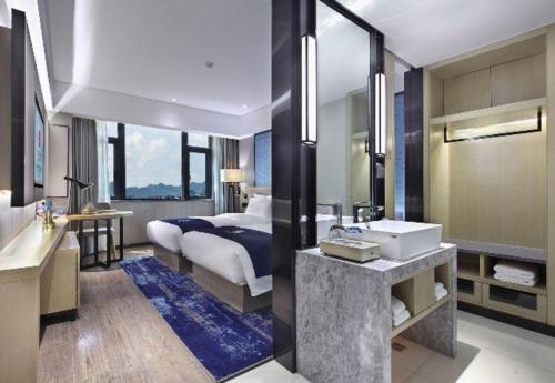 a bathroom with a bed and a sink in a room at Echarm Hotel Guilin North High Speed Railway Station in Guilin