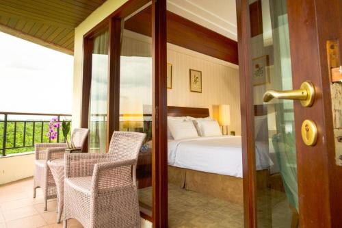 a bedroom with a bed and a table and chairs at Labersa Grand Hotel &Convention Center in Pekanbaru