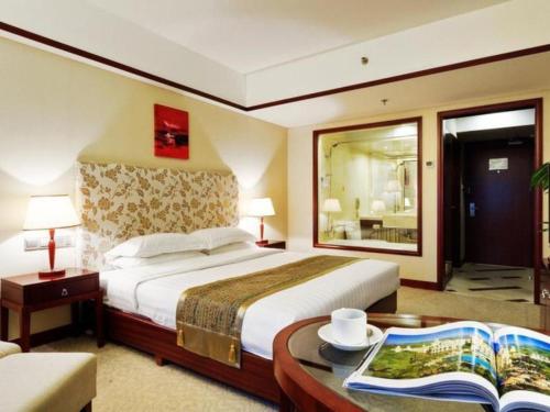 a hotel room with a large bed and a table at Starmoon Hotel in Beijing