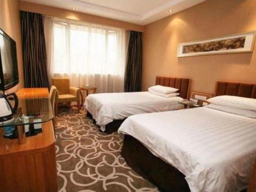 a hotel room with two beds and a television at Jin Jiang Nanjing Hotel in Nanjing
