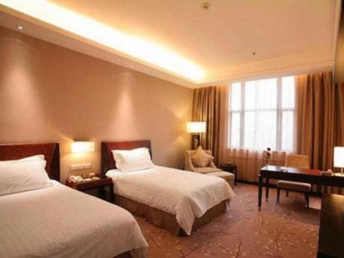 a hotel room with two beds and a desk at Jin Jiang Nanjing Hotel in Nanjing