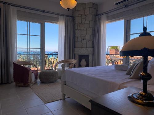 a bedroom with a bed and large windows with a view at Cumbalıca Flora in Cesme