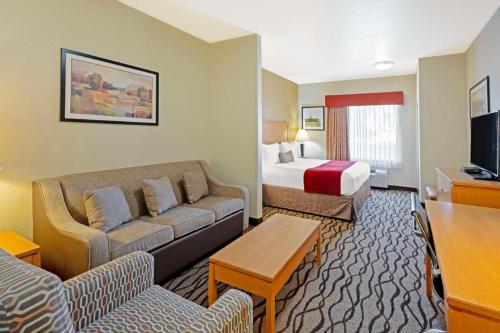 a hotel room with a couch and a bed at Best Western Plus Guymon Hotel and Suites in Guymon
