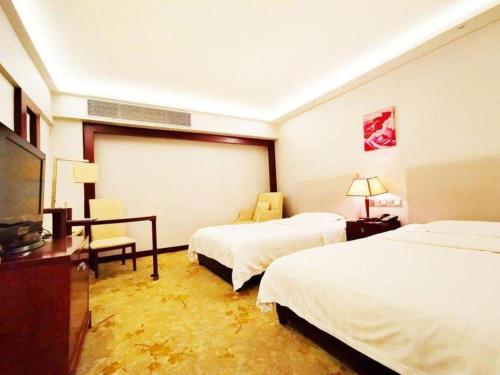 a hotel room with two beds and a desk at Starmoon Hotel in Beijing