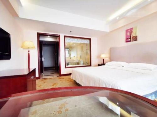 a bedroom with a bed and a tv and a tub at Starmoon Hotel in Beijing