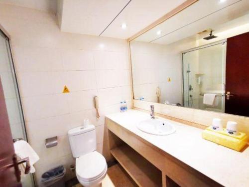 a bathroom with a toilet and a sink and a mirror at Starmoon Hotel in Beijing