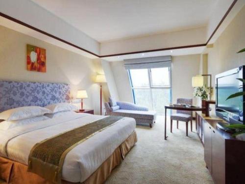 a hotel room with a large bed and a television at Starmoon Hotel in Beijing