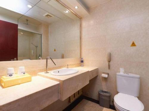 a bathroom with a sink and a toilet and a mirror at Starmoon Hotel in Beijing
