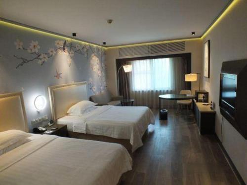 a hotel room with two beds and a television at Starmoon Hotel in Beijing