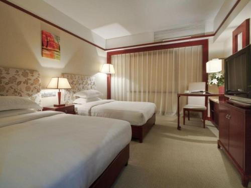 a hotel room with two beds and a television at Starmoon Hotel in Beijing