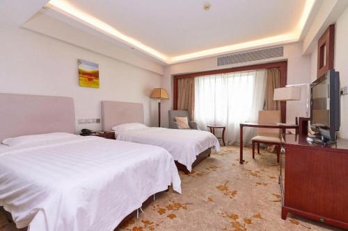 a hotel room with two beds and a television at Starmoon Hotel in Beijing