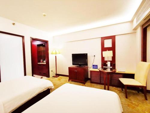 a hotel room with two beds and a television at Starmoon Hotel in Beijing