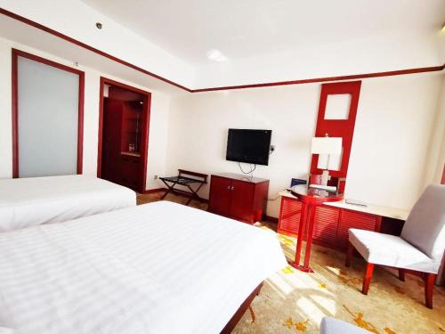 a hotel room with two beds and a television at Starmoon Hotel in Beijing