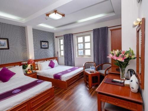 a hotel room with two beds and a desk at Hồng Hạc hotel in Ho Chi Minh City