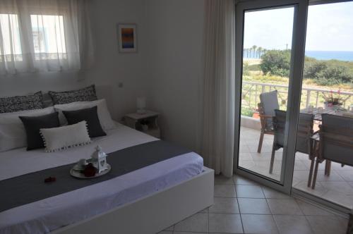 a bedroom with a bed and a view of the ocean at Villa Imerti Kiotari in Kiotari