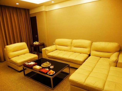 a living room with a couch and two chairs and a table at Best Western Plus Fuzhou Fortune Hotel in Fuzhou