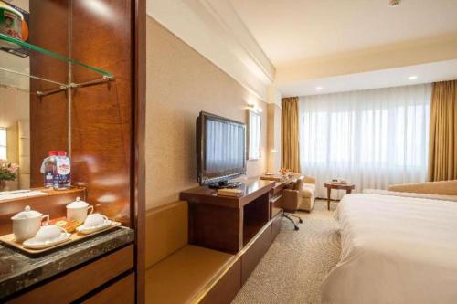 a hotel room with a bed and a television at Best Western Plus Fuzhou Fortune Hotel in Fuzhou