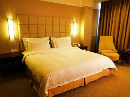 a hotel room with a large bed and a chair at Best Western Plus Fuzhou Fortune Hotel in Fuzhou