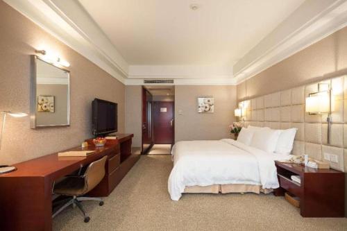 a hotel room with a bed and a desk and a computer at Best Western Plus Fuzhou Fortune Hotel in Fuzhou