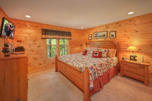 een slaapkamer met een bed in een kamer met houten wanden bij Bearfoot Memories Holiday home in Gatlinburg