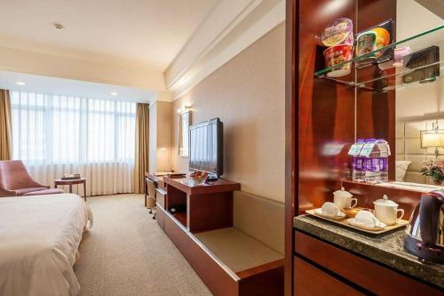 a hotel room with a bed and a television at Best Western Plus Fuzhou Fortune Hotel in Fuzhou