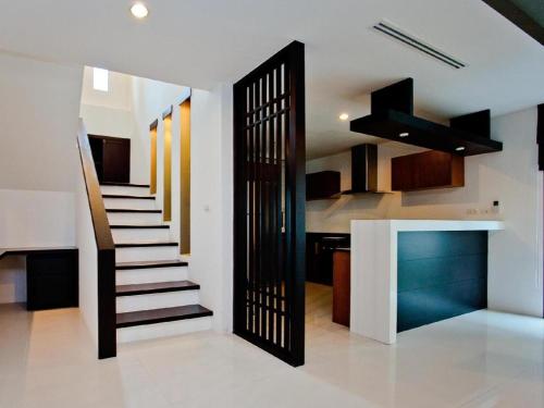 a staircase in a living room with a kitchen at Ocean Breeze Residence in Khao Lak