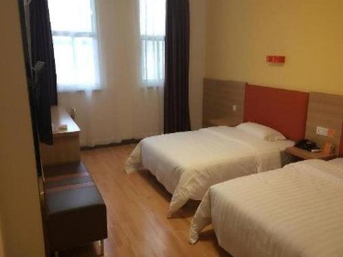 a hotel room with two beds and a television at 7 Days Inn Yongcheng Central Station in Houling