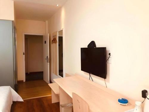 a living room with a flat screen tv on a wall at 7 Days Inn Hohhot Hailiang Xinhua Square Metro Station in Hohhot