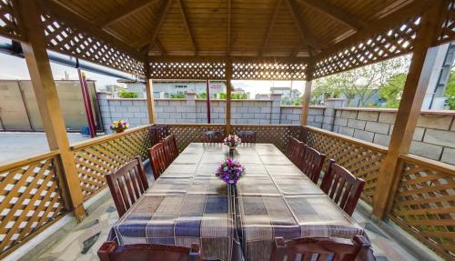 einen langen Tisch in einem Pavillon mit Stühlen und Blumen in der Unterkunft Vila Sophia in Vama Veche